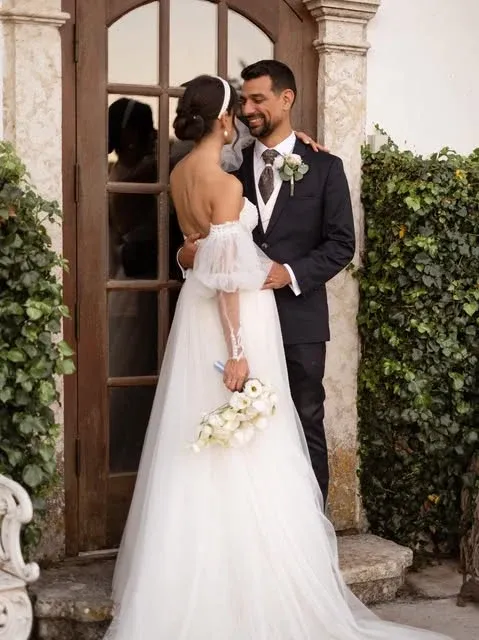 Noivos junto à entrada de uma casa
