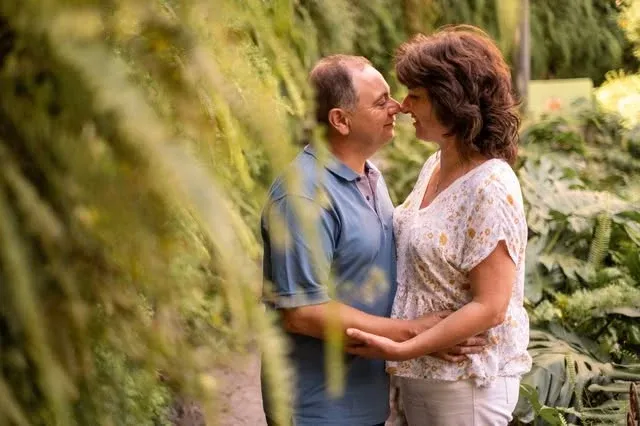 Casal a trocar um olhar junto a uma árvore